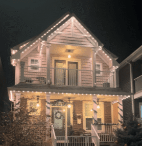 Permanent warm white roofline lighting on a two-story home at night
