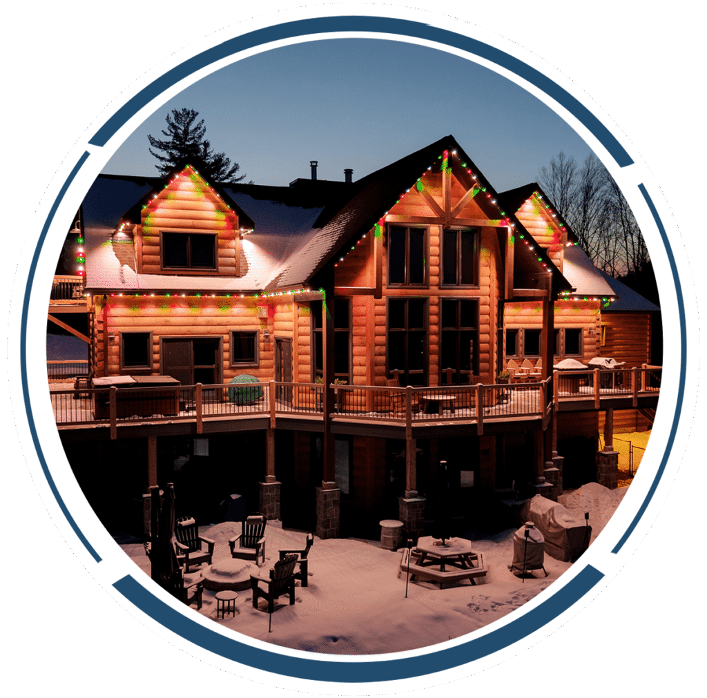 Colored roofline lights on a log home in winter
